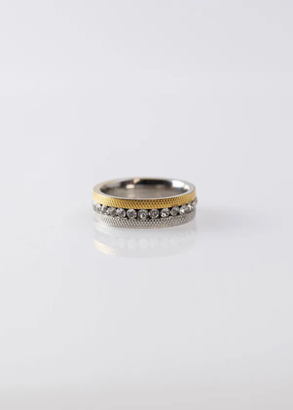 A gold and silver two-line ring with zirconium lobes