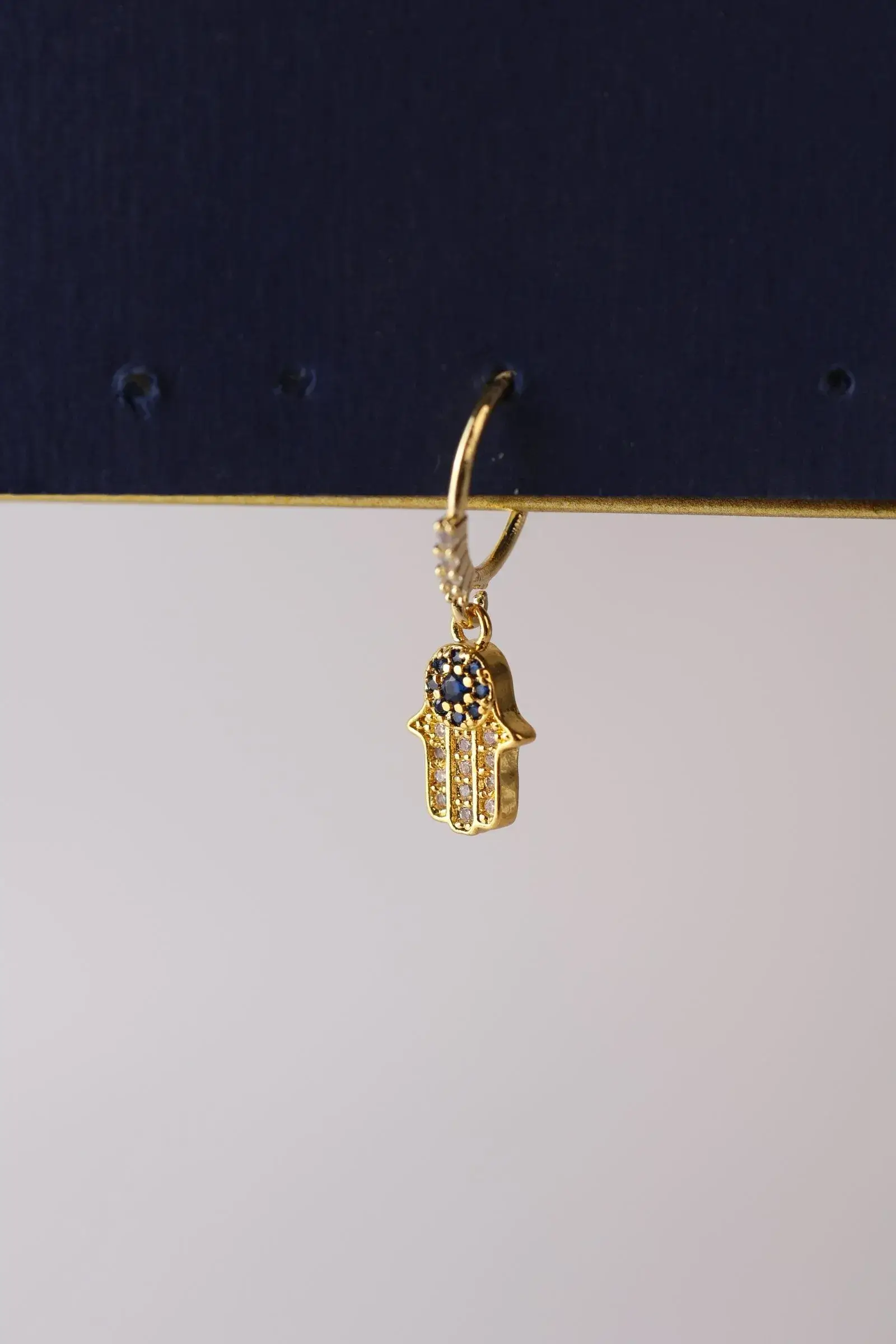 Piercing ear pendant in the shape of a palm