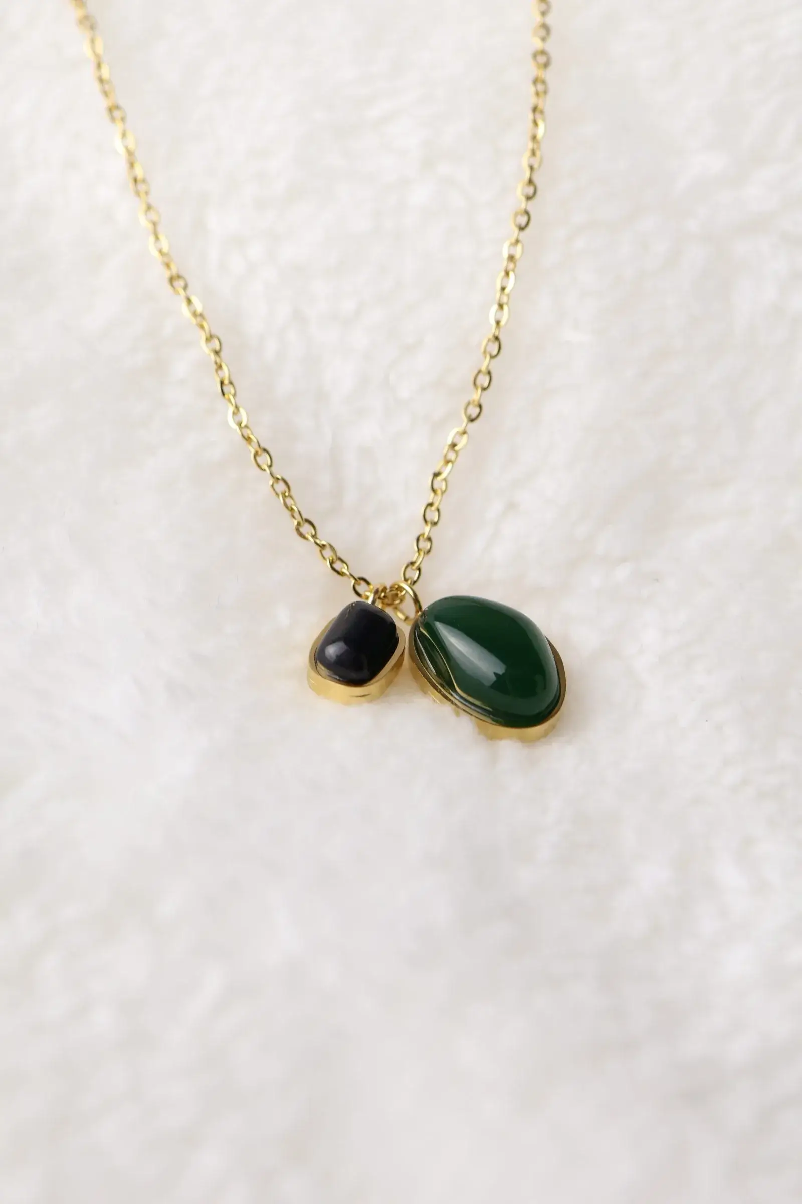 A chain of two bracelets with black and olive beads